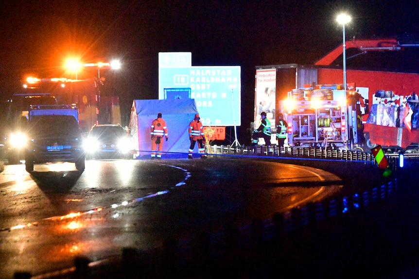 Strada di notte con i soccorritori sulla scena dopo l'incidente. 
