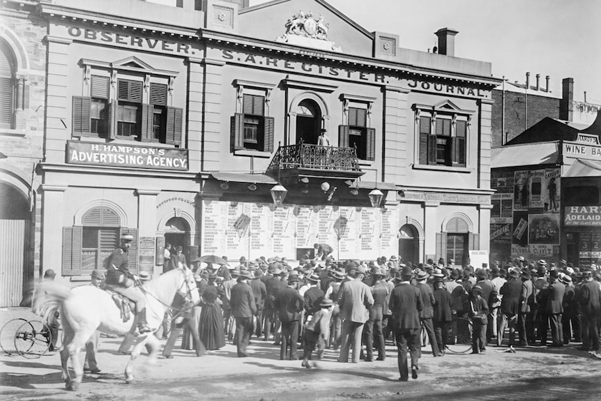 Men and women watch the results of the 1896 election being posted.