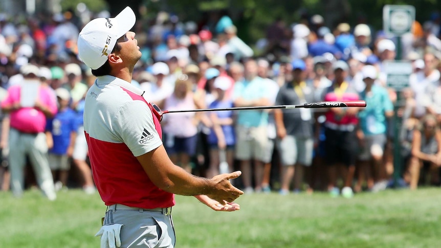 Jason Day throws his club in the air after missing a putt