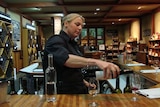 Cellar door staff pours wine into glass for tasting.