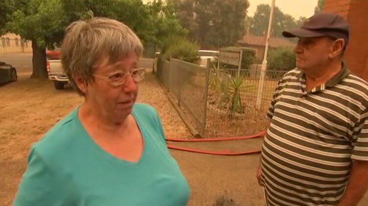 Mary Novak stands in front of a CFA building in Myrtleford under an orange haze.