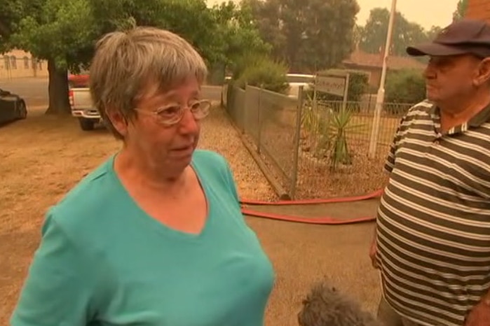 Mary Novak stands in front of a CFA building in Myrtleford under an orange haze.