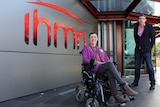 A woman in a wheelchair and a man standing outside the Illawarra Health and Medical Research Institute