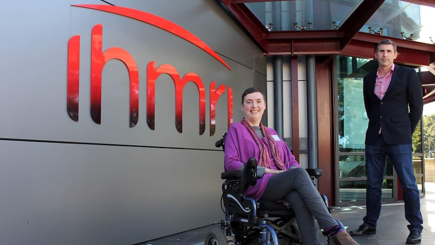 A woman in a wheelchair and a man standing outside the Illawarra Health and Medical Research Institute