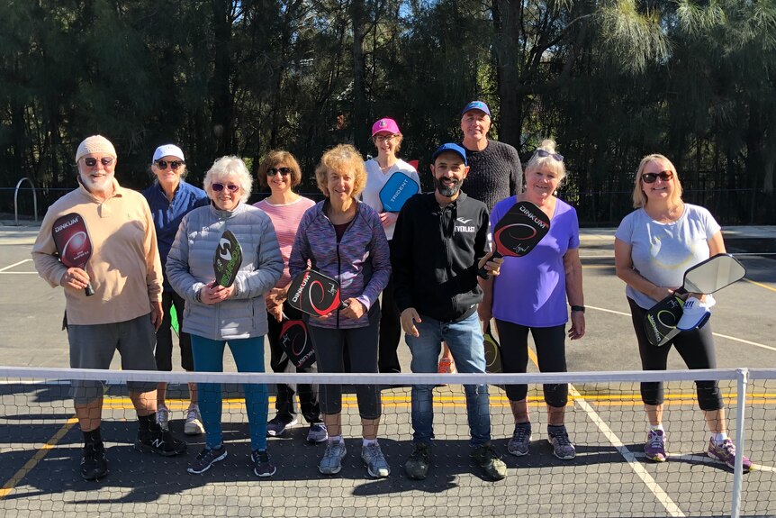 A group of elderly neighbours meet daily for friendly rounds of pickleball 