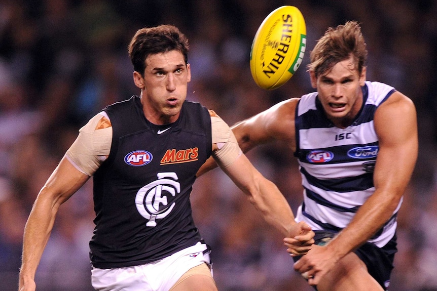 Michael Jamison of Carlton wins the ball against Tom Hawkins of Geelong