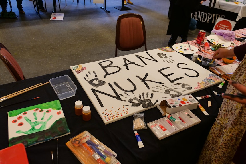 Signs on a table saying 'ban nukes'.