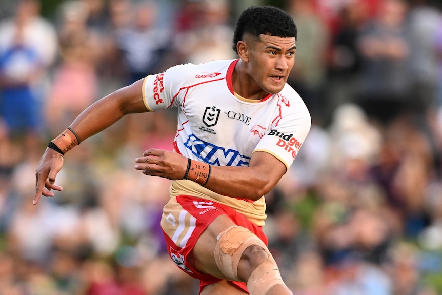 A Dolphins NRL player kicks the ball against the Cowboys in a preseason trial.