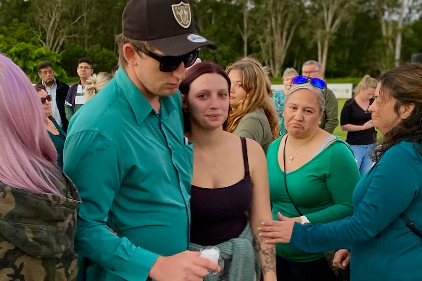 An emotional Emma Wilkinson is led through crowds at her sister's vigil.