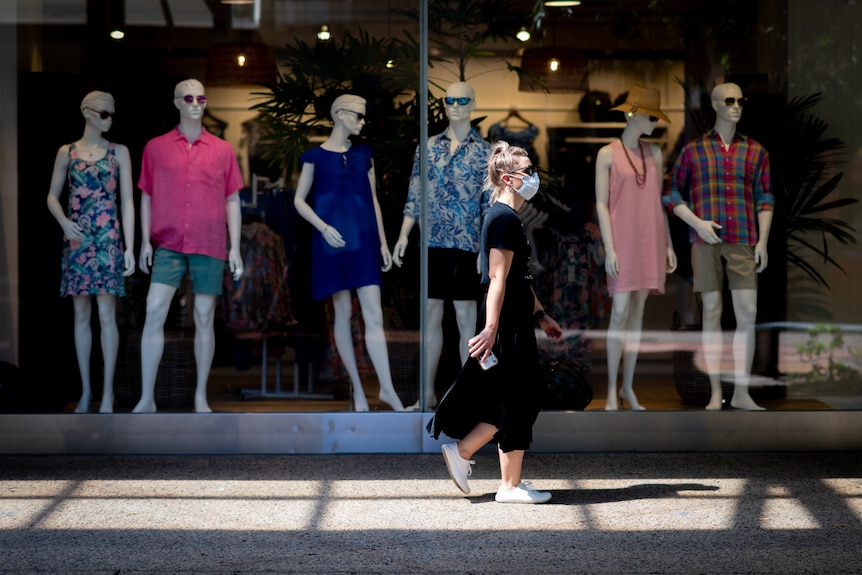 A woman wearing a mask walking through the Darwin CBD during a COVID lockout.