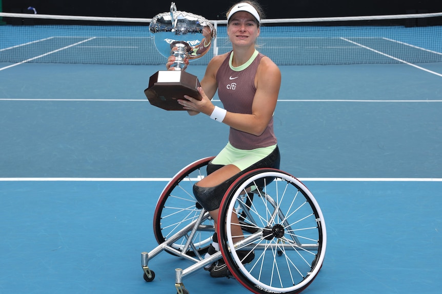 Diede de Groot holds the 2004 Australian Open trophy after winning the women's wheelchair singles final.