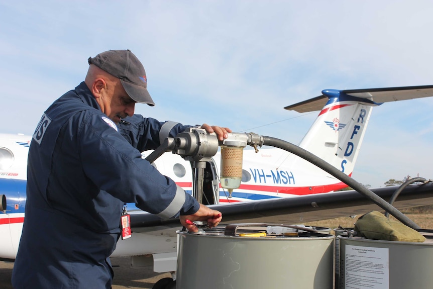 RFDS pilot Conrado Cialiero operates a hand-pump to refuel his plane from a 200-litre drum at Ivanhoe.
