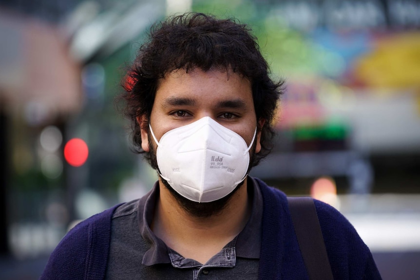 A man is wearing a mask as he walks by Peppers Waymouth Hotel, believed to be the source of the Parafield coronavirus cluster.