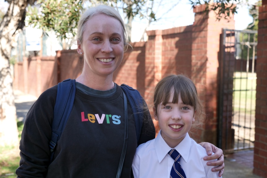A woman in a Levi's jumper with a school kid