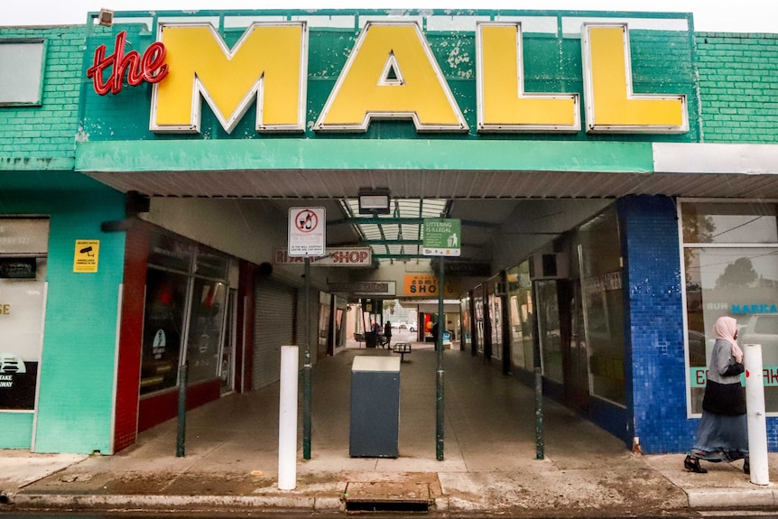 A woman walks passed the Bell Street Mall.