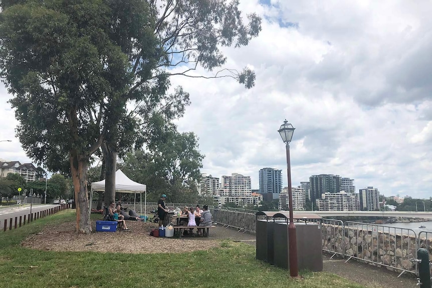 Storm clouds gather as families secure a spot on Brisbane's Kangaroo Point cliffs for NYE fireworks on December 31, 2017.