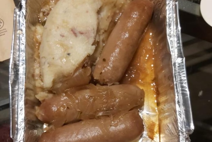 Alfoil container with sausages and potato