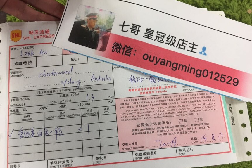 An order form showing what Qi Ge is sending to a customer and another slip of paper with the name of his WeChat store.