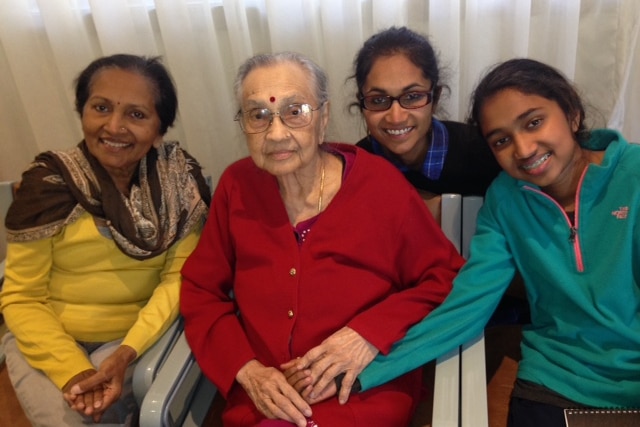 Four generations of women from a Sri Lankan-Australian family sitting together, smiling