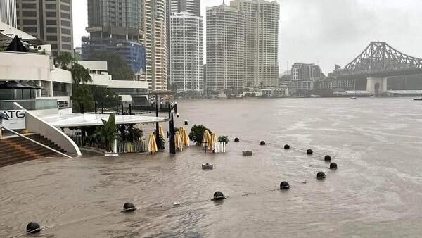 Water rises over a riverfront restaurant precinct, making the restaurants look like part of the river