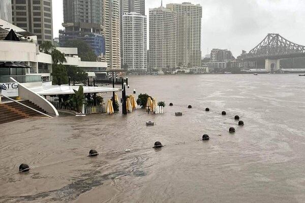Water rises over a riverfront restaurant precinct, making the restaurants look like part of the river