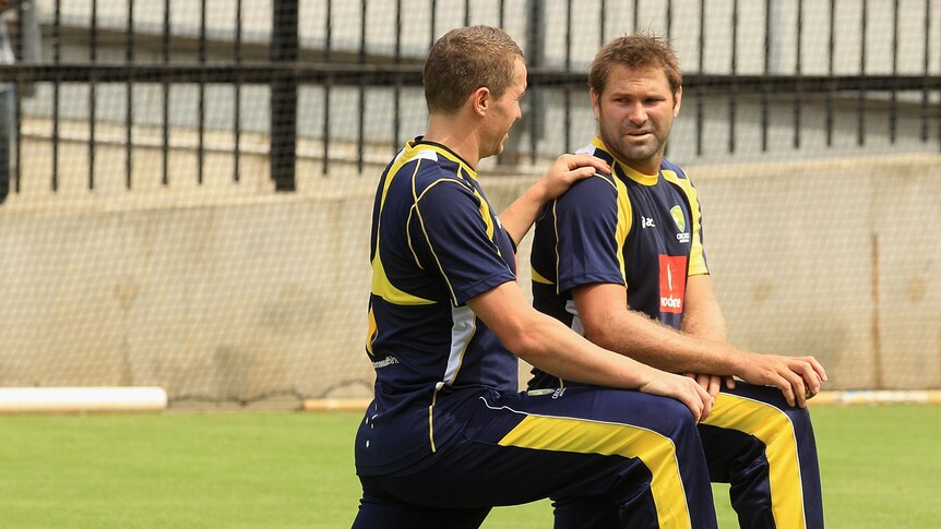 Ryan Harris stretching with Peter Siddle.