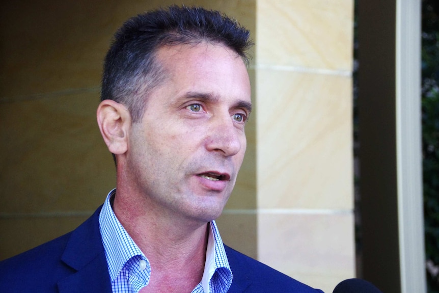 A tight shot of Paul Papalia speaking into a microphone during a TV interview outside State Parliament.