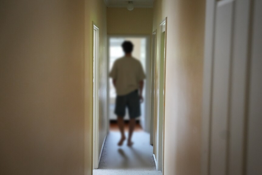 A man photographed anonymously in his house, who uses ketamine