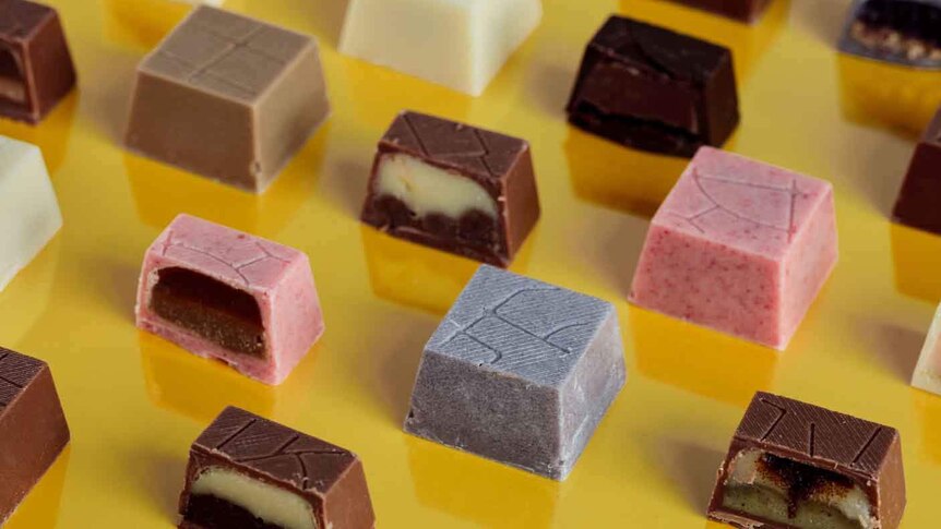 Chocolates lined up against a yellow background.