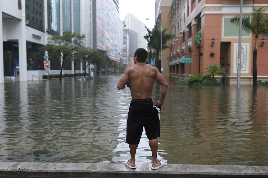 A man watches on as Floodwaters continue to rise in Miami