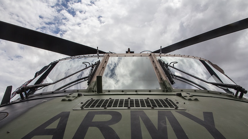 The cockpit of an army helicopter with reflection of clouds in the window