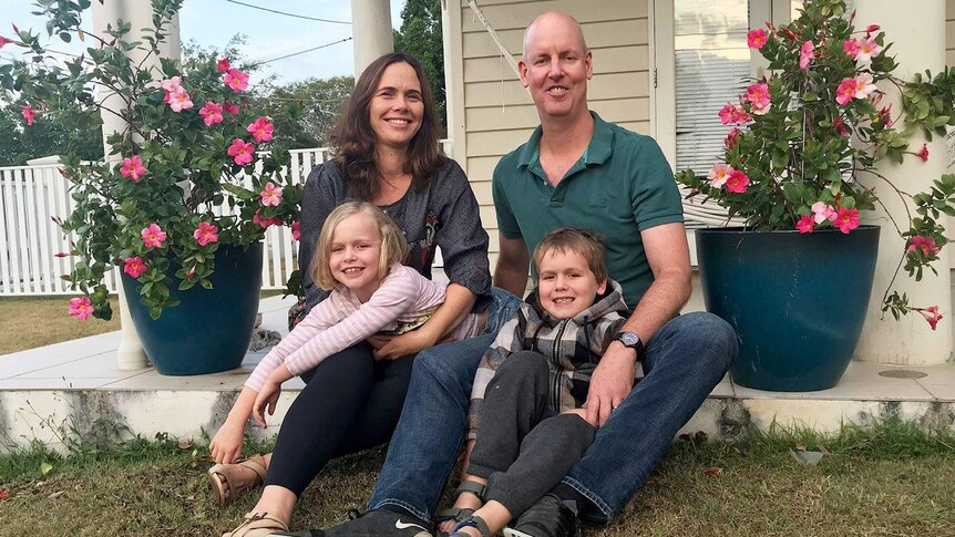 Sarah and Richard Mattsson, with children Holly and Digby, sit outside their home in Brisbane.