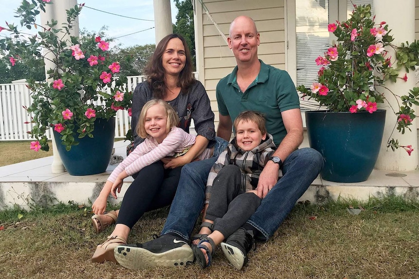 Sarah and Richard Mattsson, with children Holly and Digby, sit outside their home in Brisbane.