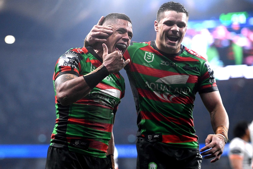 Two South Sydney NRL players celebrate a try scored against the Wests Tigers.