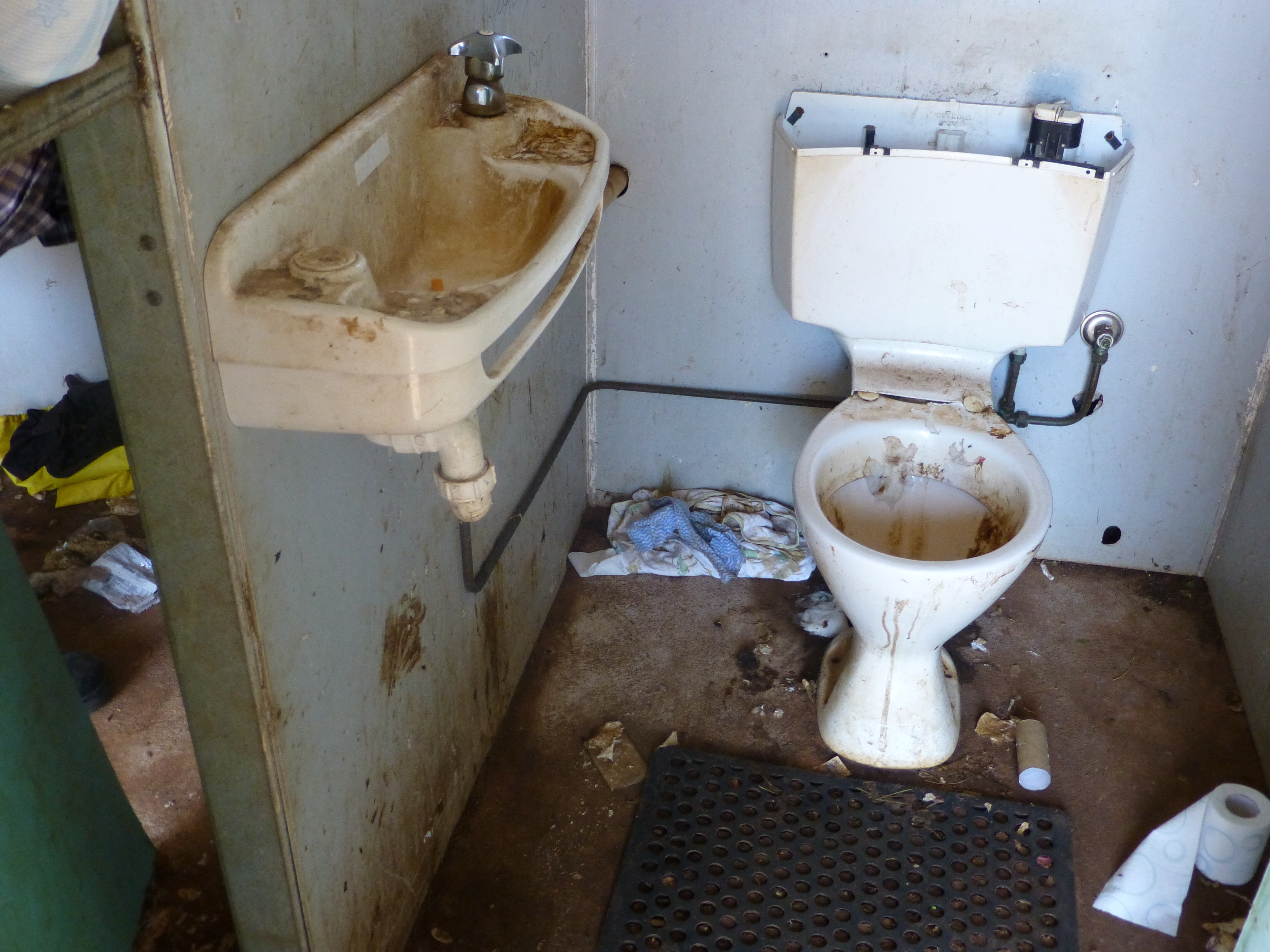 A dirty bathroom with a sink and toilet