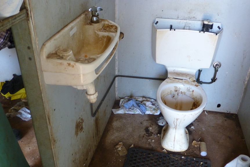 A dirty bathroom with a sink and toilet