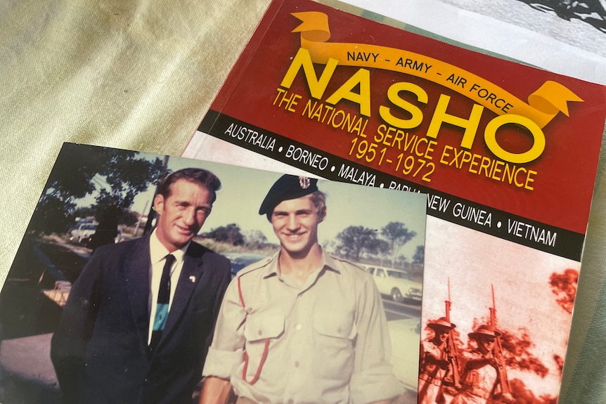 An old photograph of a soldier and his dad lay on top of a Nasho booklet 