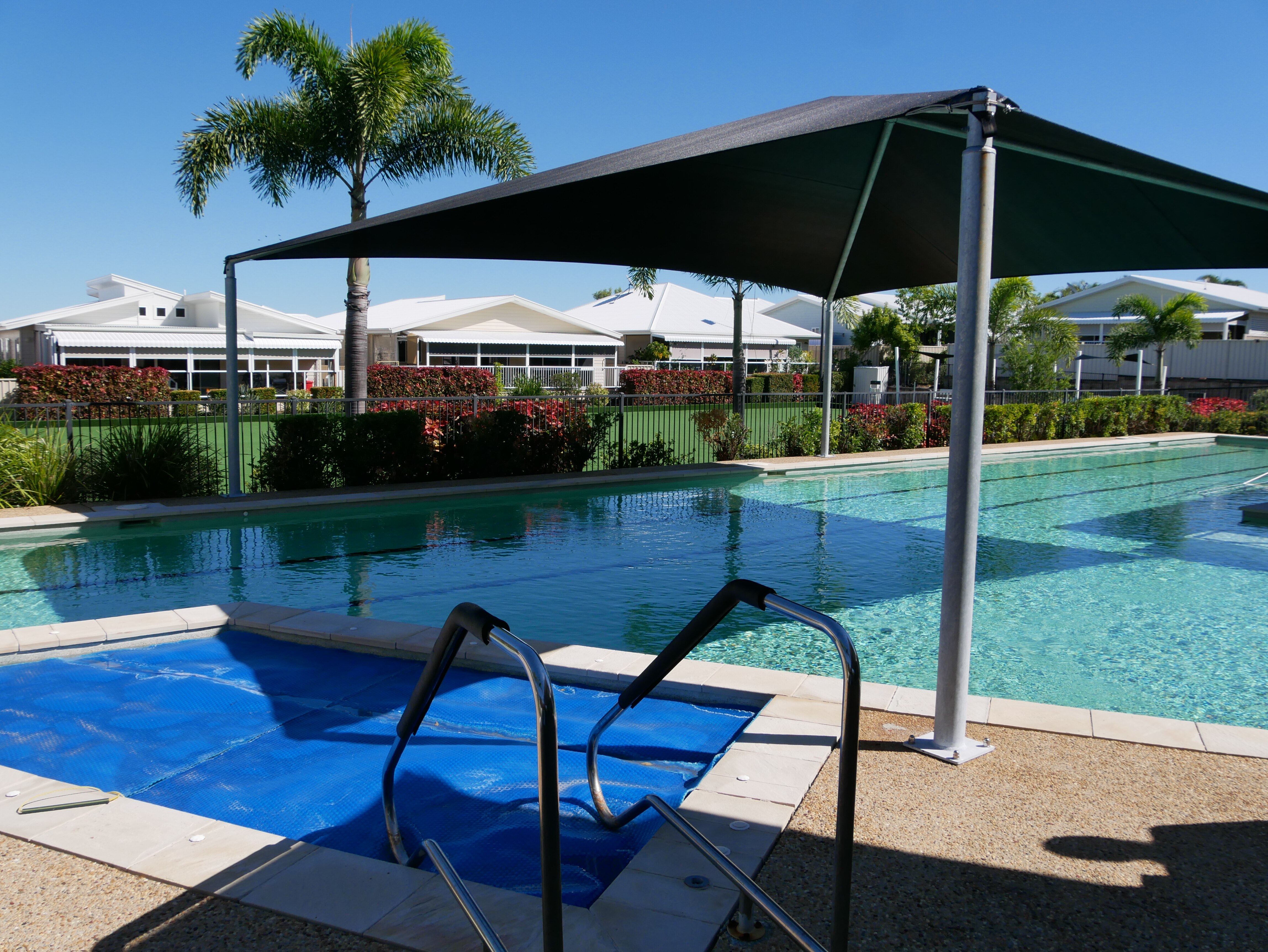 Swimming pool and bowling green in foreground at retirement village. 