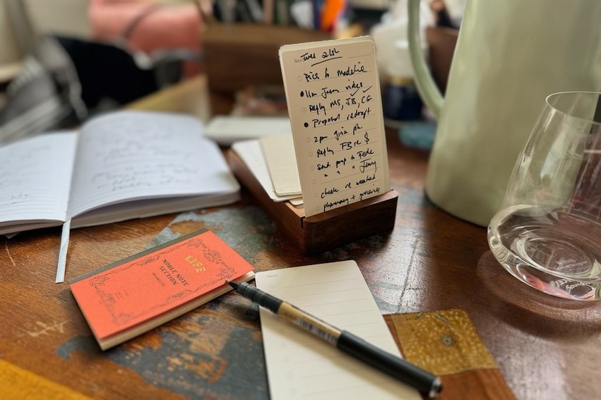A handwritten to do list sitting on the desk of author Charlotte Wood, with a notepad and notebook nearby.