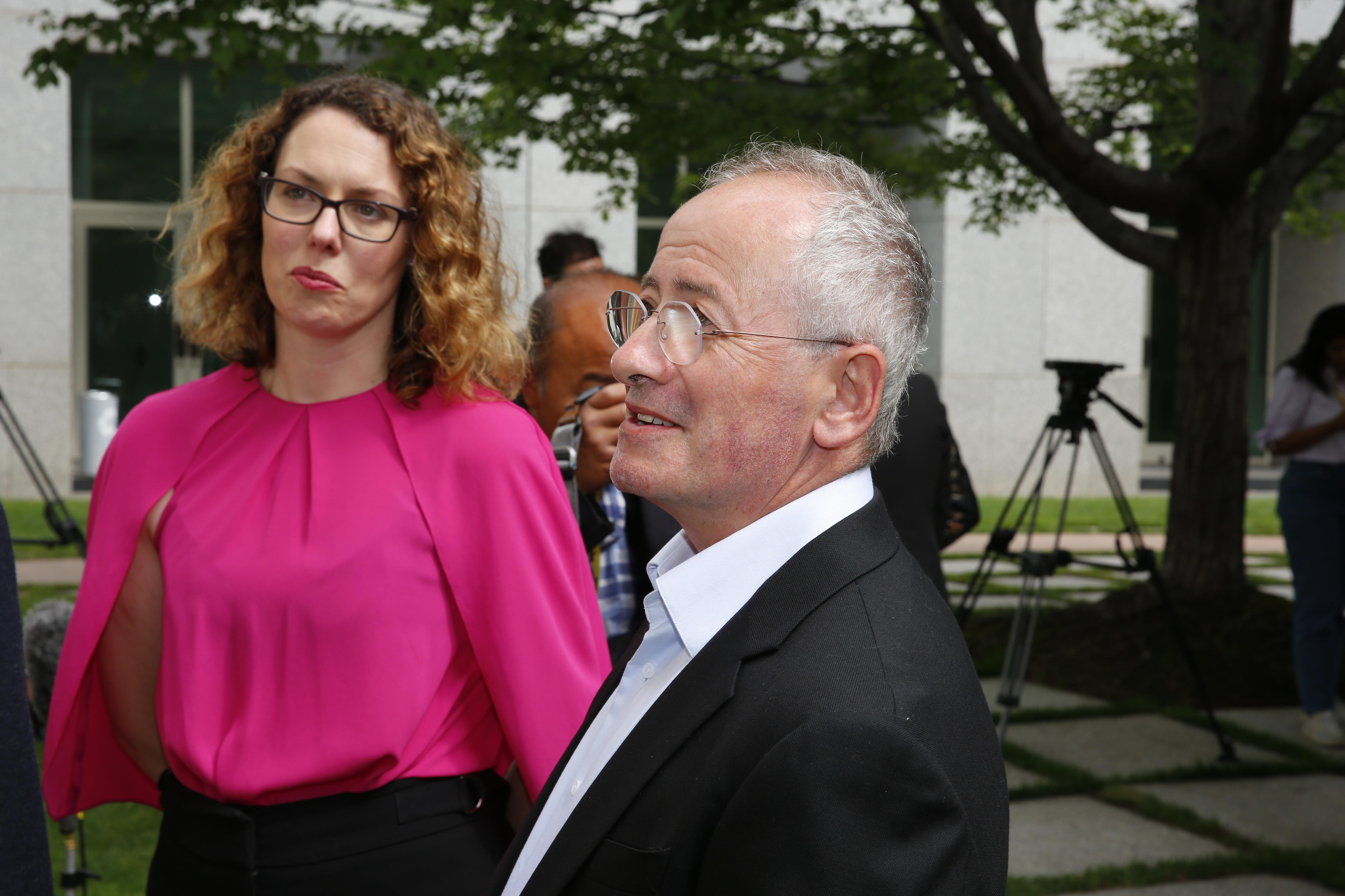 A woman and a man look to the left of the camera.