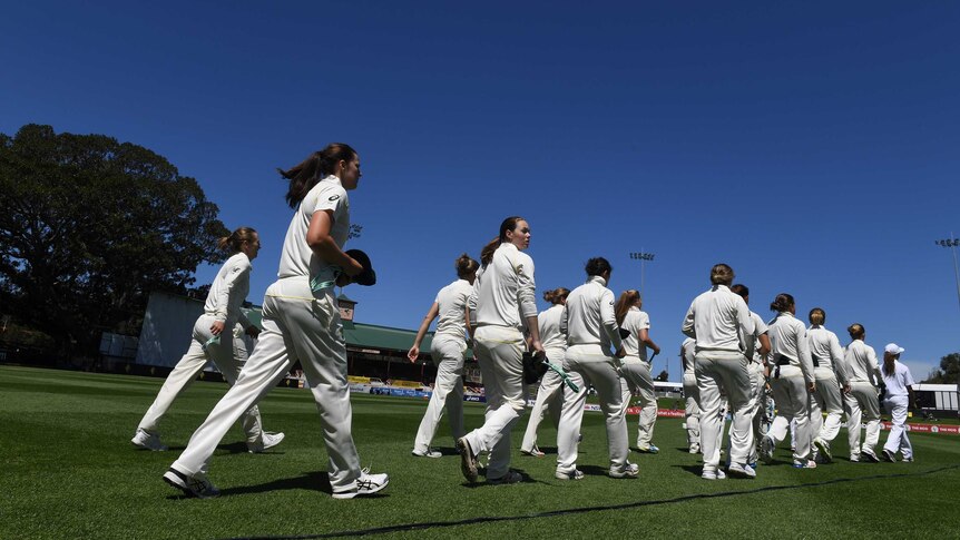 Australia's and England's Womens Ashes teams walk onto North Sydney Oval for day one of the Test.