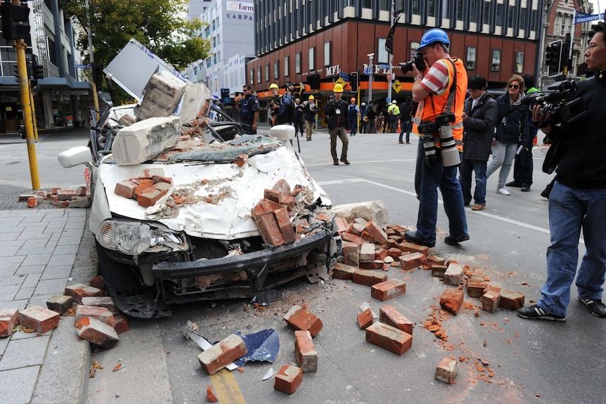 A car is flattened by bricks and rocks.