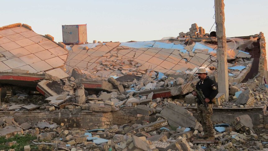 A member of the Iraqi security forces stands in the rubble of destroyed buildings in Ramadi.