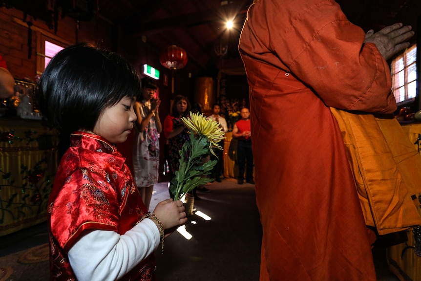 Kaitlyn in the ancestral room with visiting Vietnamese abbot, Thich Giac Minh and family.