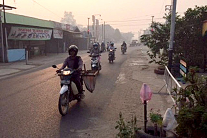 Motorcyclists ride through haze in Central Kalimantan province.