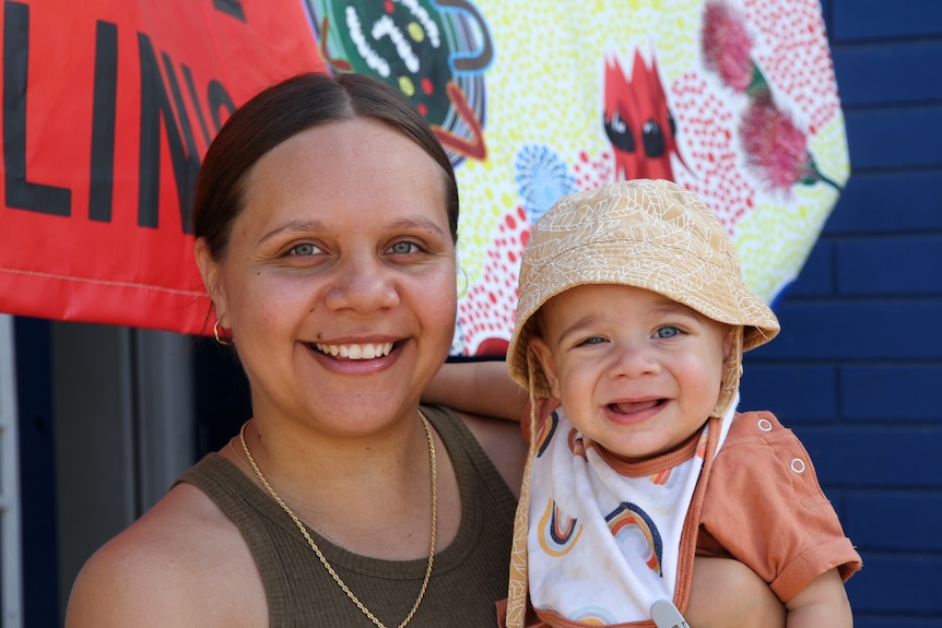 A young woman holds a baby in her arms