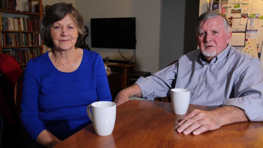 Julie and John Feary sit at a table in their Bateman granny flat.