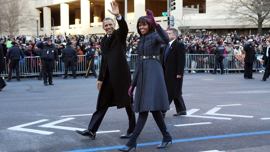 Barack and Michelle Obama walk along Pennsylvania Avenue.