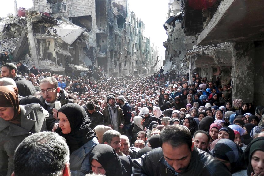 Thousands of Palestinian refugees cue for food supplies in ruins of Damascus