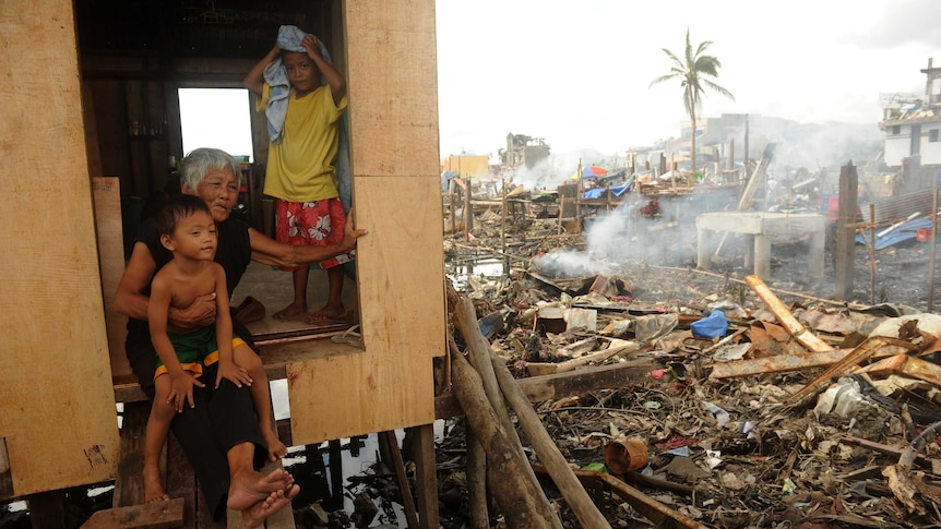 Trinidad Genario sits with her grandchildren in typhoon-devasted Tacloban, Philippines.